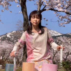桜の下でクリスタルボウルを演奏する新井晴美